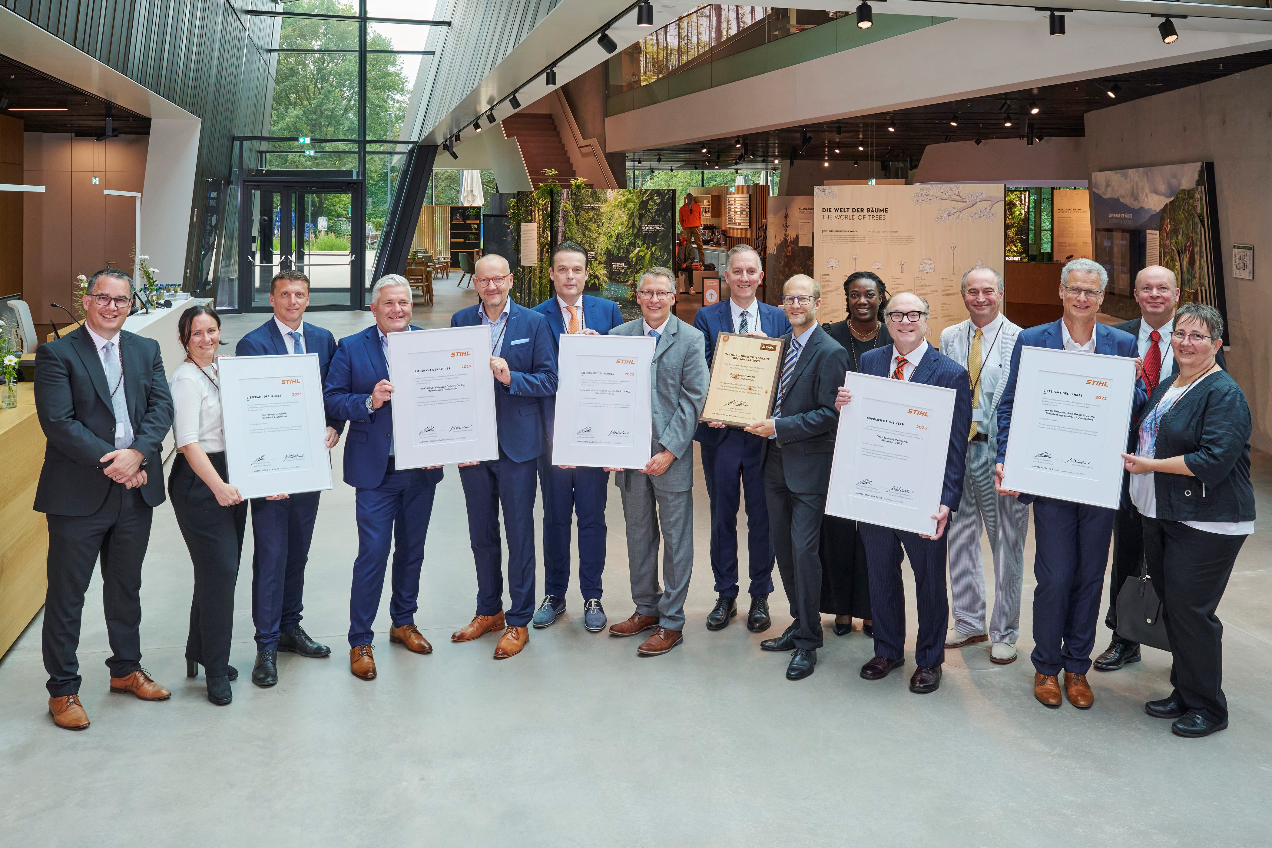 Martin Schwarz, STIHLs styremedlem for produksjon og materialer (til venstre), og Marc Moser, Vice President Purchasing (bak til høyre), sammen med de prisbelønte leverandørene i STIHL Brand World.